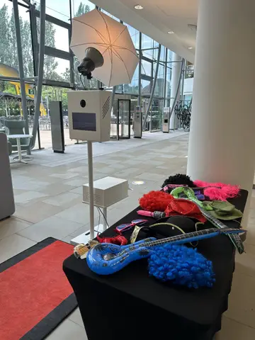 Open photo pod setup with an umbrella flash and a table of colourful photo props